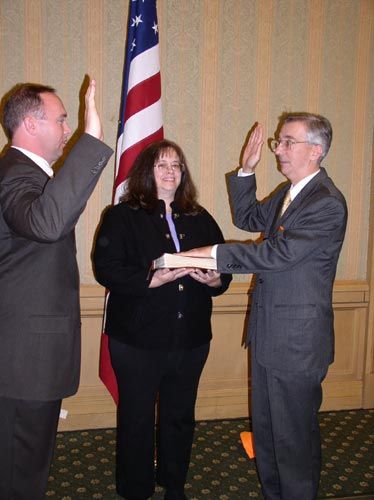 County Clerk Gary Clemens witnesses oath of office by Supervisor-elect Eugene Delgaudio with wife Sheila  holding the Holy Bible.