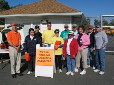 Supervisor Eugene Delgaudio joins other leaders of the Sterling community in meeting up April 29 and picking up trash on Sterling Boulevard. Mowing costs are raised by donations to the recycling bin at Park View High School in the background. 